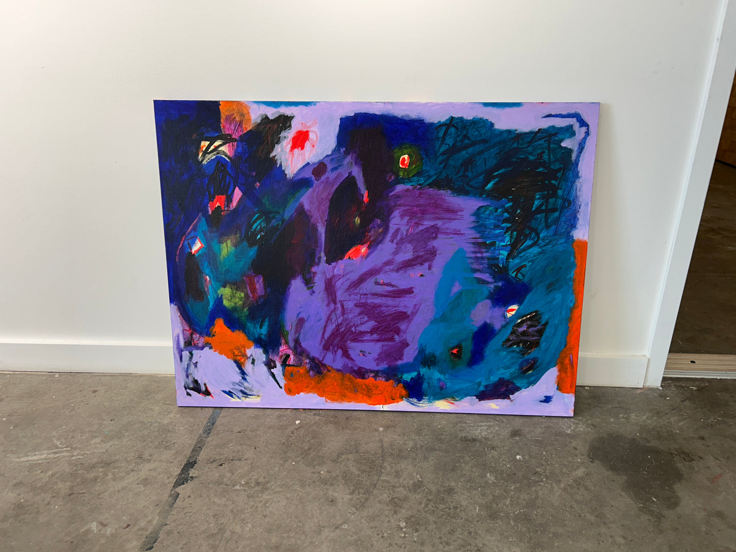 Abstract painting with vibrant colors on a white wall.