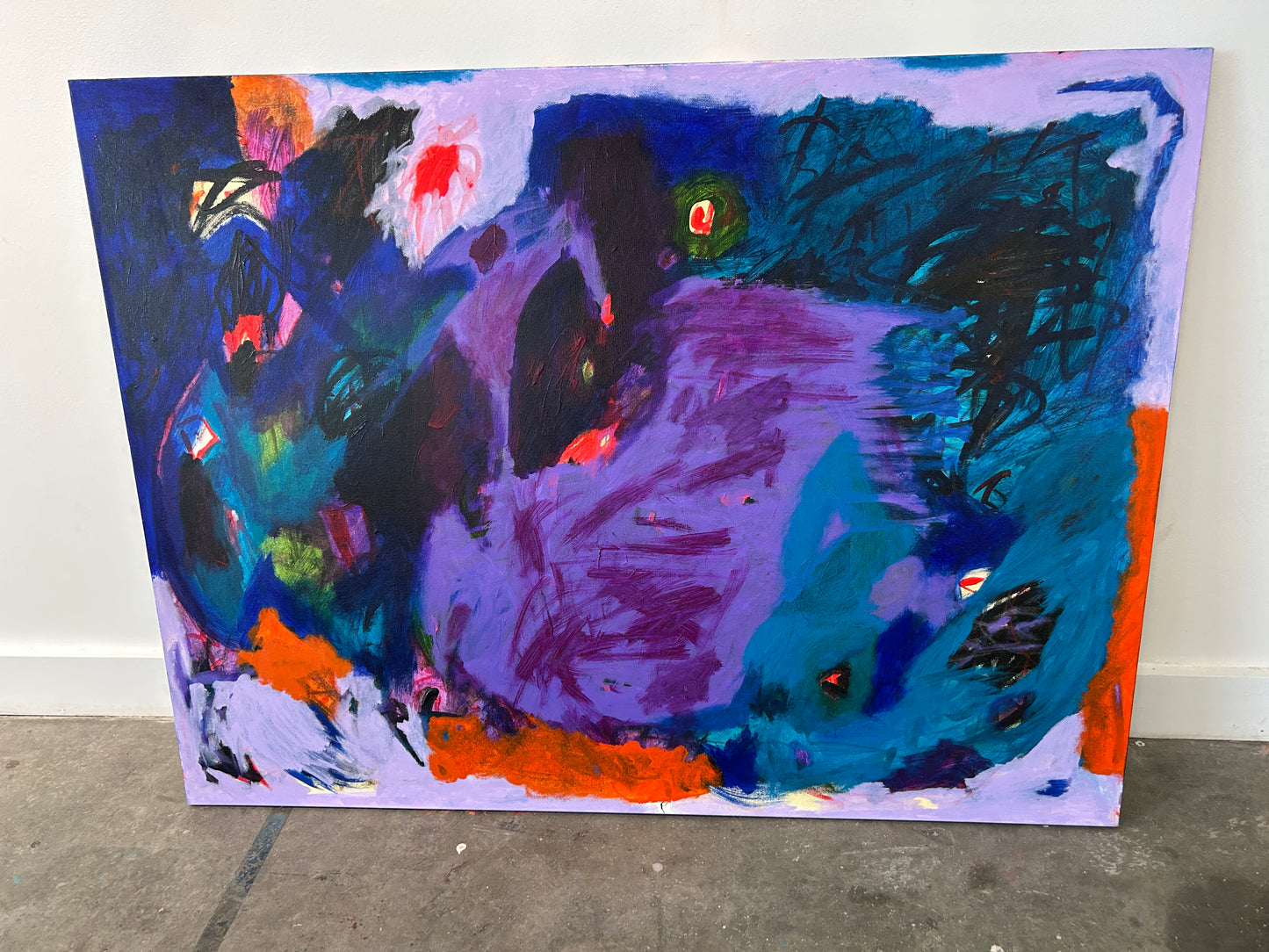 Abstract painting with vibrant colors on a white wall.