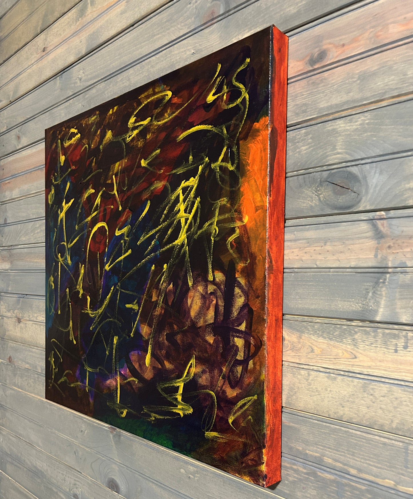Abstract painting with vibrant colors on a wooden wall