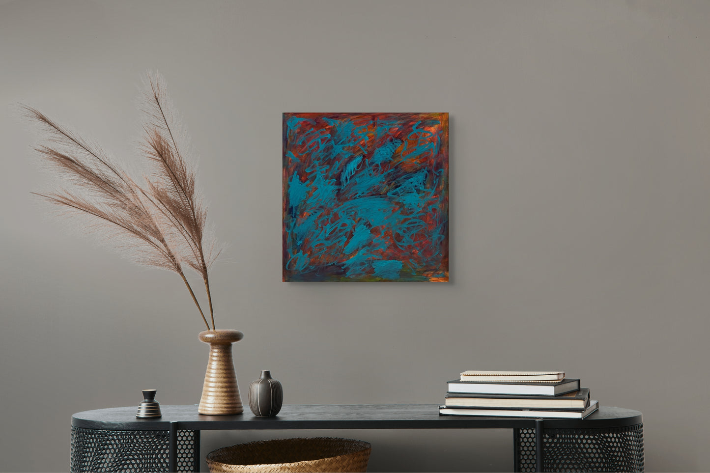 Abstract painting on a wall above a console table with decorative items.